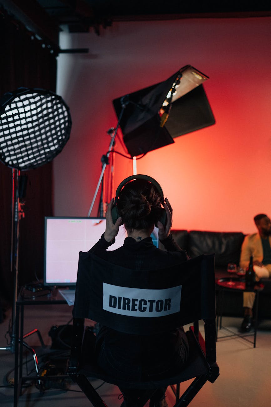 a person with headphones sitting on black directors chair