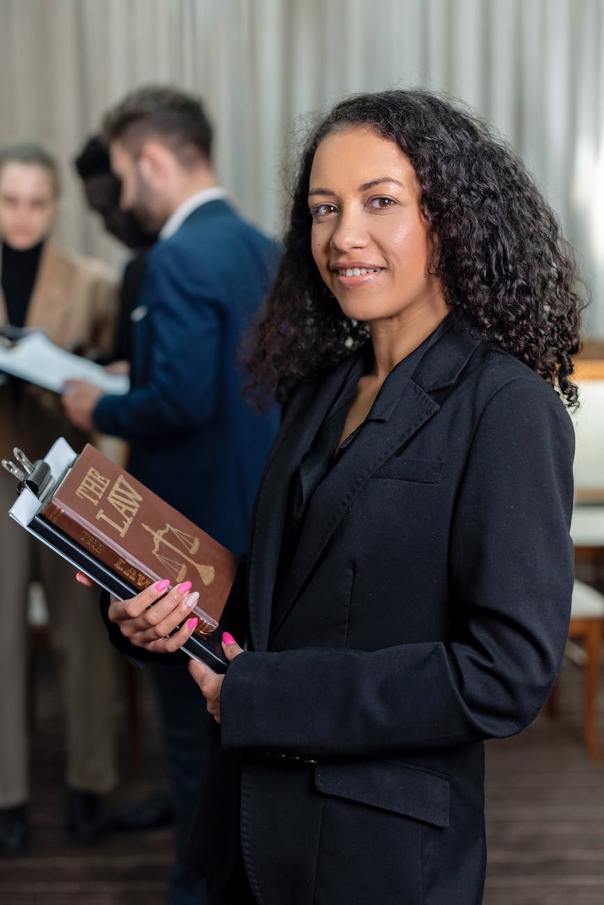 a woman in black blazer holding a law book