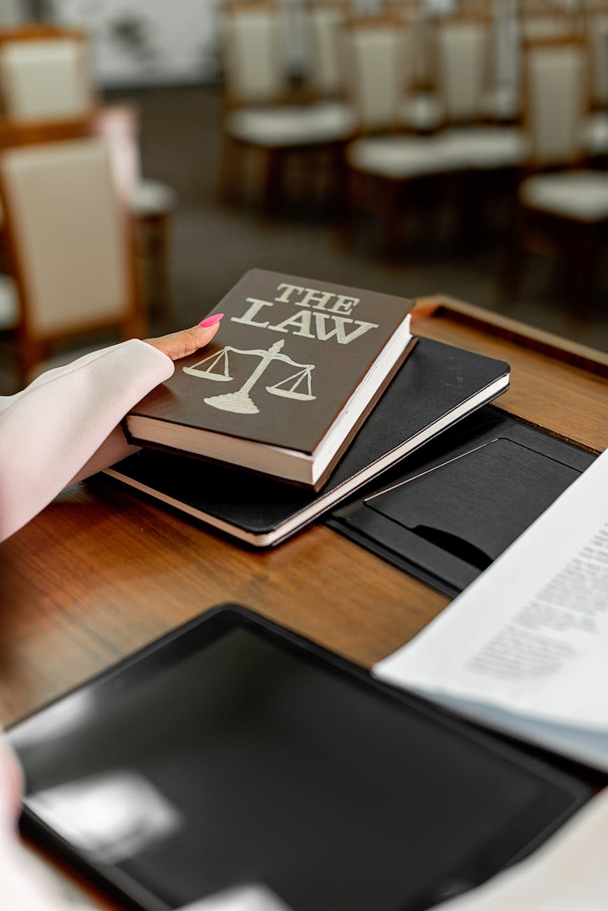 a hand holding a book of law