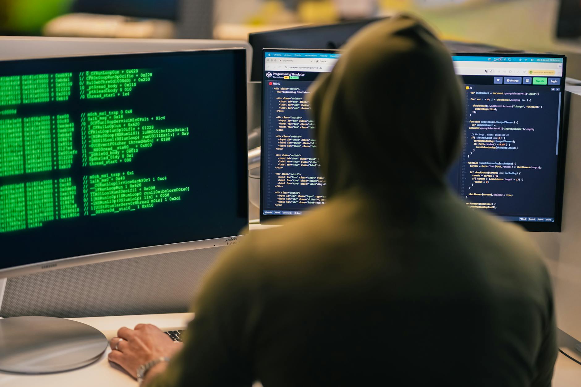 hacker coding on multiple monitors at night