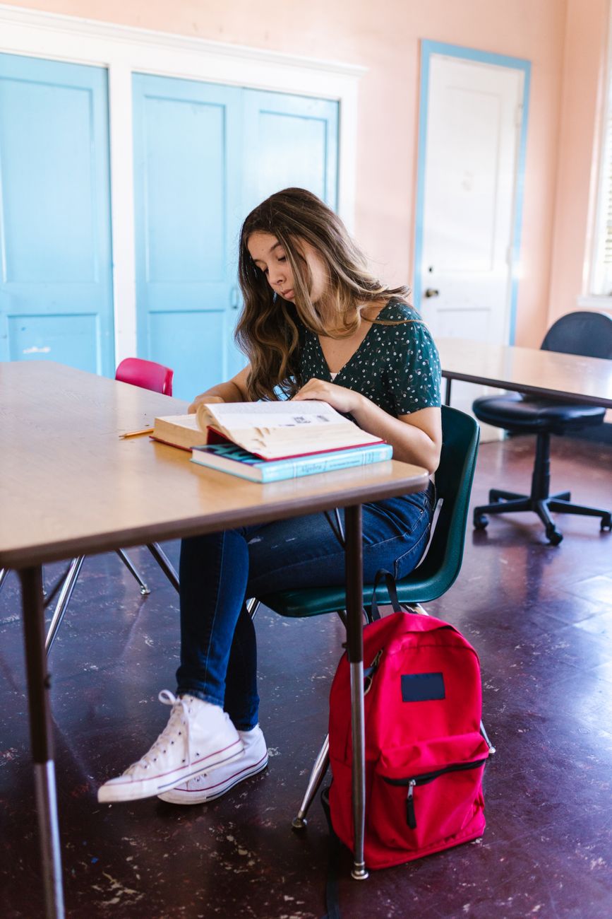 woman reading book inside a classroom