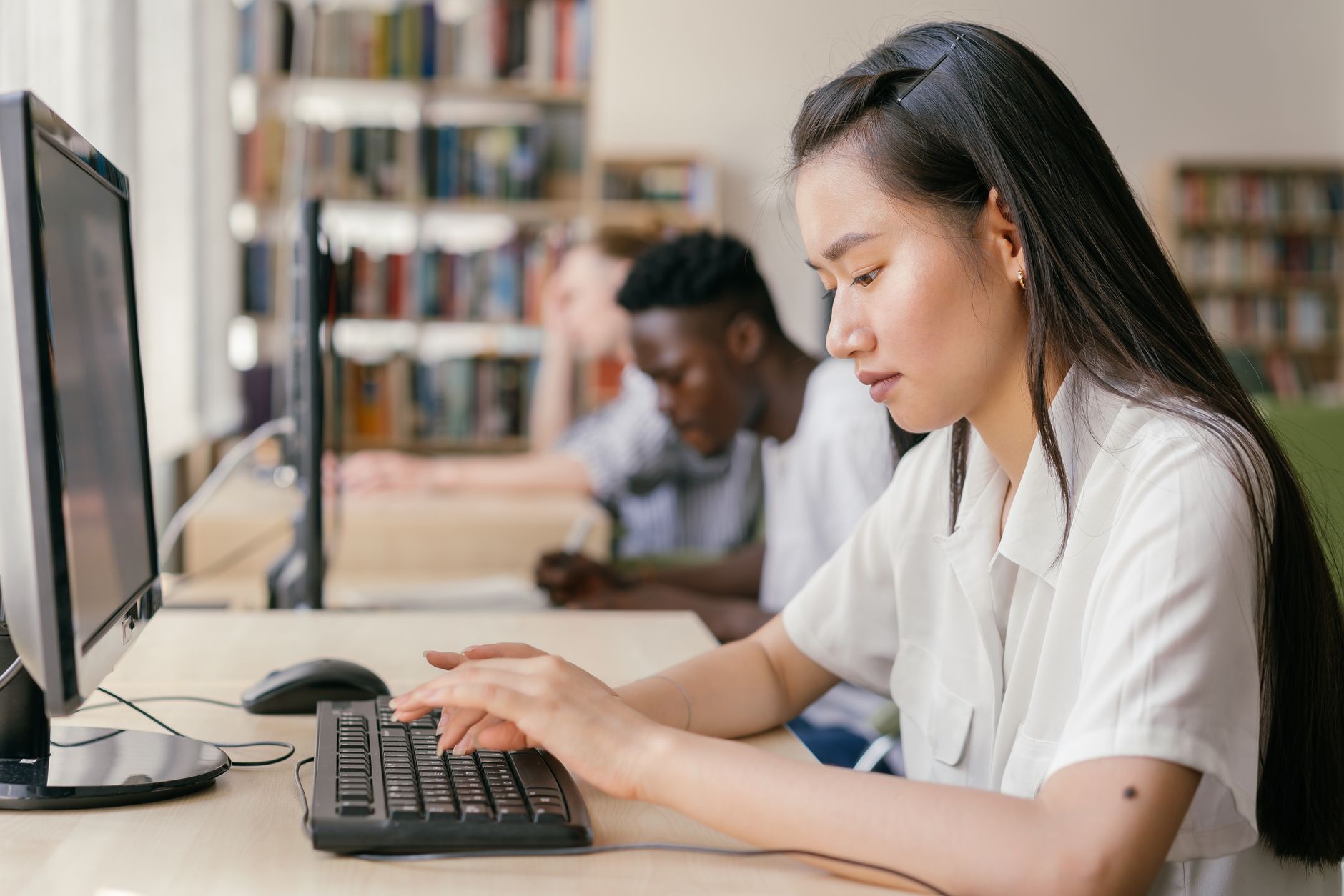 woman in white button up shirt using computer