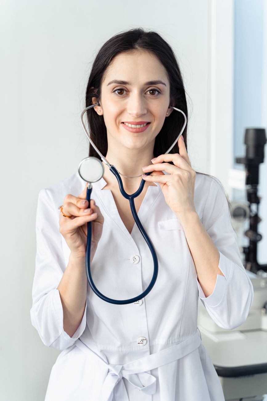 woman smiling while holding a stethoscope